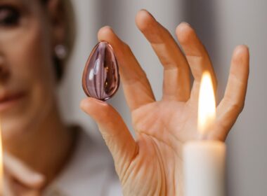 Person Holding Lighted Candle in Front of Person