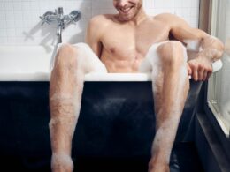 topless man sitting on bathtub